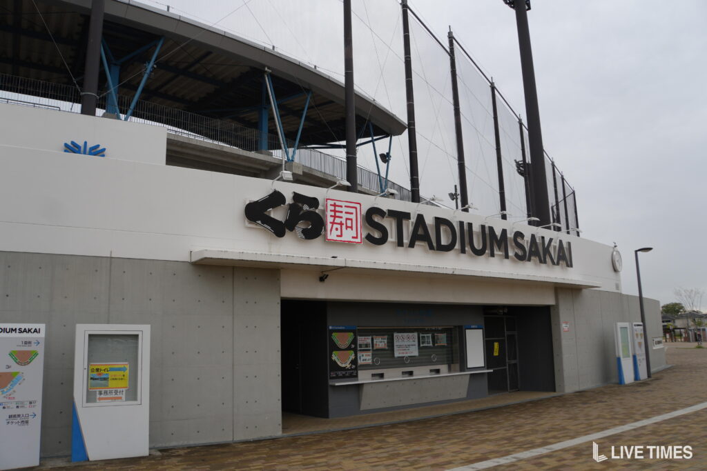 Facade of Stadium Sakai with a ticket booth and large sign reading 'STADIUM SAKAI' with Japanese characters above the window area