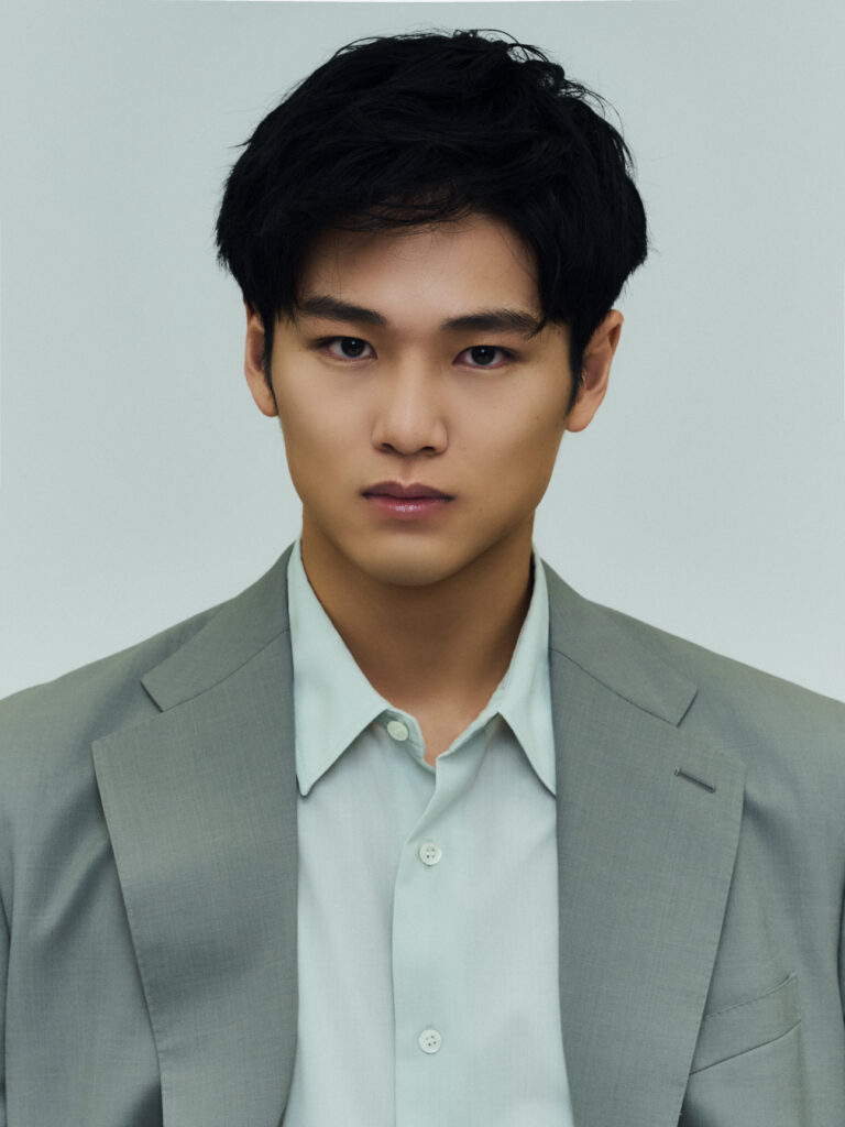 Professional headshot: young Asian man in a pale blue shirt and gray suit, looking directly at the camera against a neutral background.