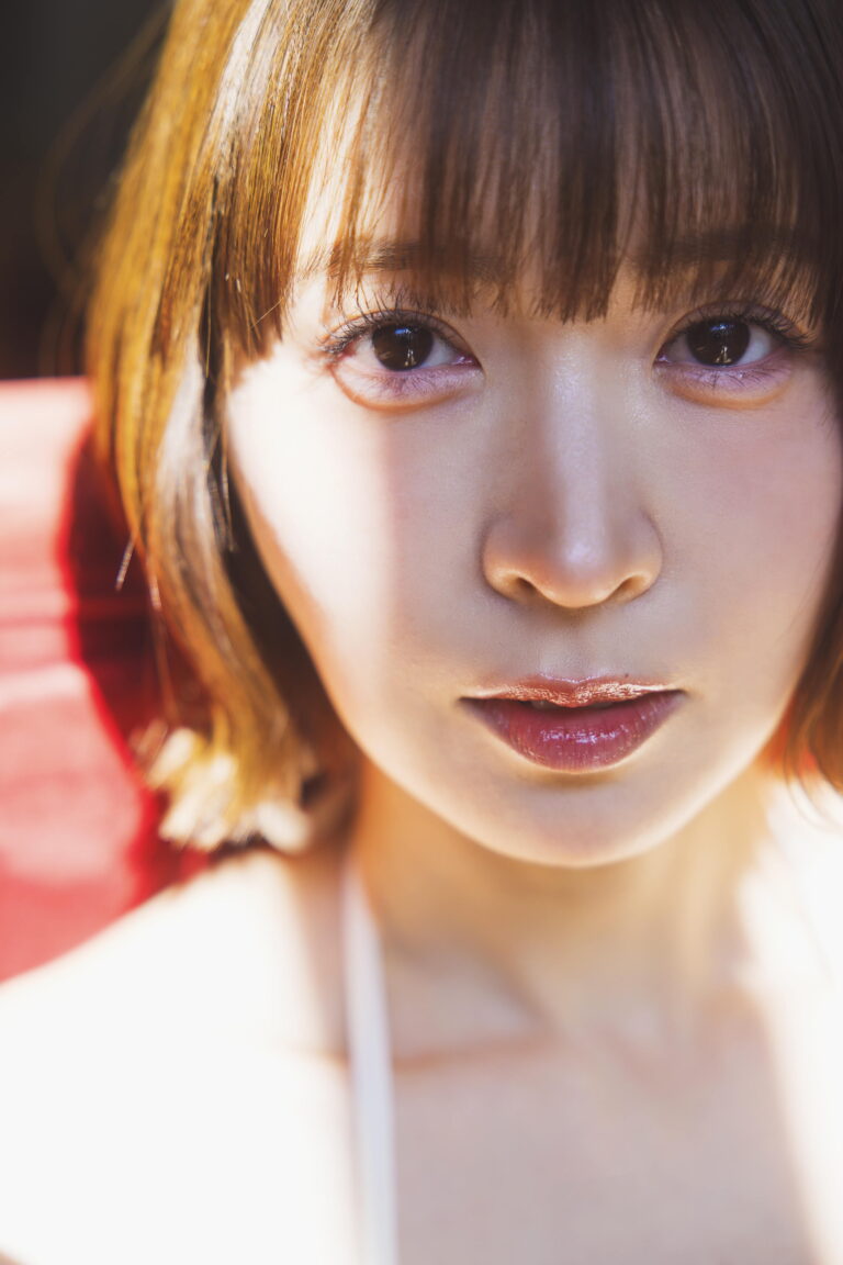 Close-up portrait of a young woman focusing on her eyes and lips with warm lighting.