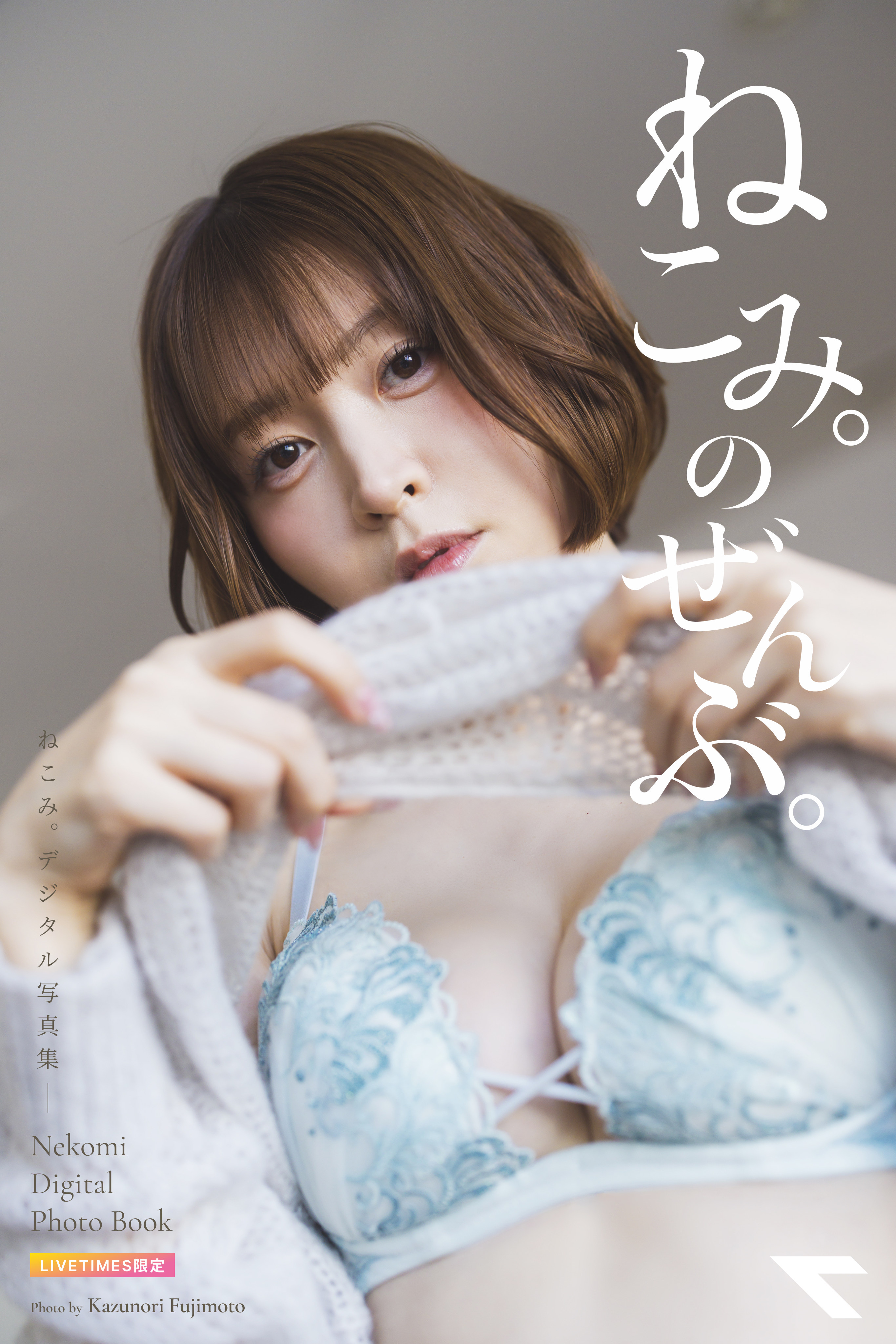 Close-up of a young woman with brown hair wearing blue lace lingerie, gazing softly at the camera with a knit blanket nearby; Japanese text overlays the right side.