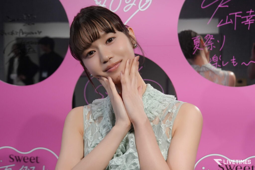 Portrait of a young woman posing with hands near her face against a pink background with white cursive text.
