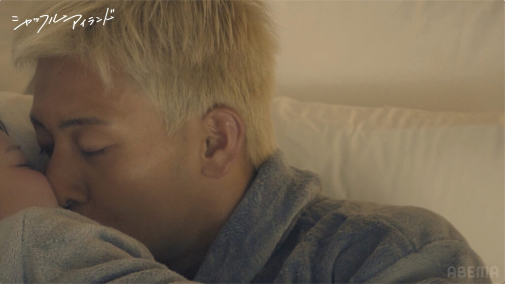 Young person with blond hair sleeping on a pillow, wearing a gray fleece hoodie.