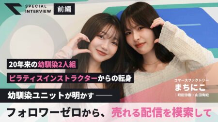 笑顔の二人がハートを作るポーズ。カラフルな背景と大きな見出し入りのインタビュー特集表紙。