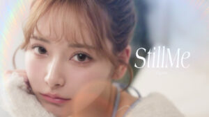 Close-up portrait of a young woman with soft makeup and warm lighting; the word 'StillMe' appears on the right as an overlay.